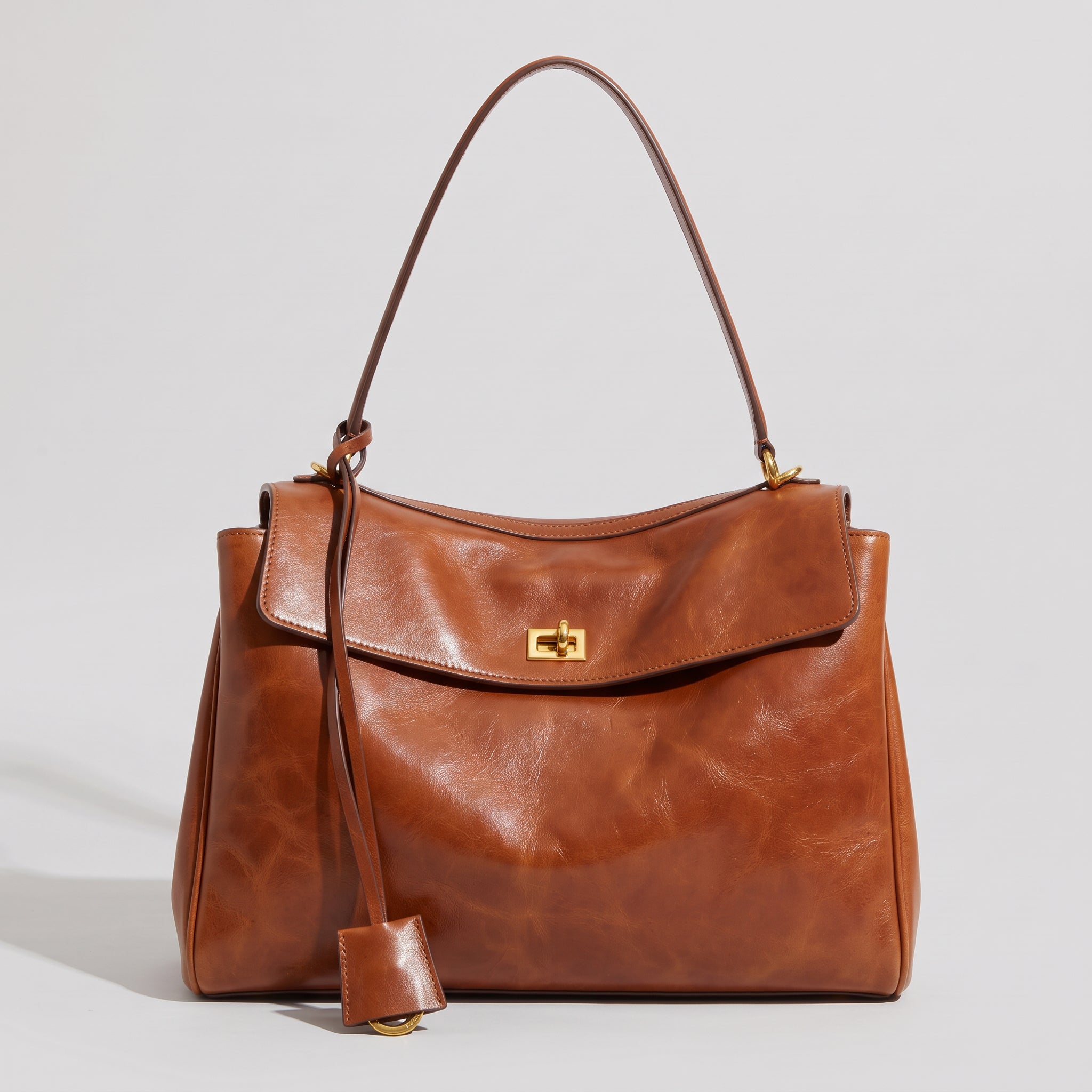 Elegant Women's Handbag with Curved Flap and Structured Top Handle